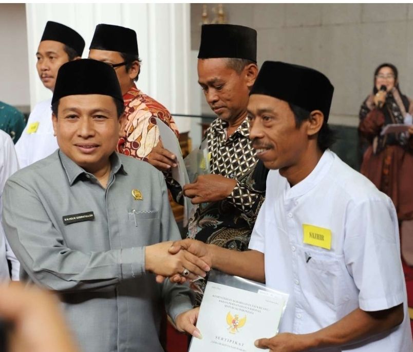 Keterangan gambar : Ketua DPRD Kabupaten Bekasi, BN.Holik Qhodratullah secara simbolis memberikan wakaf ke 200 Nazir