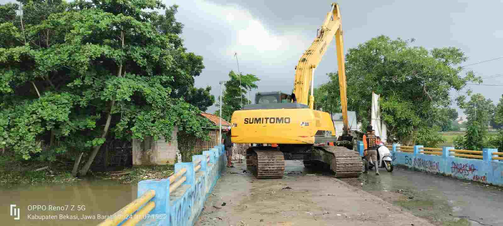 Escavator pengerukan sampah di jembatan kali Ciherang