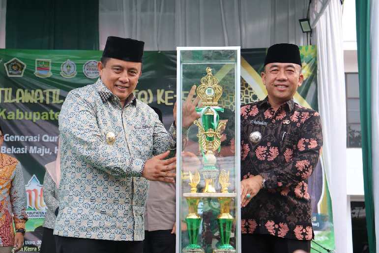 Keterangan poto : Pj Bupati Bekasi, Dedy Supriyadi menyerahkan trophy Juara Umum MTQ ke-56 tingkat Kabupaten Bekasi kepada Camat Cikarang Utara, Enop Can, di panggung utama sekaligus menutup gelaran MTQ ke-56 di Halaman Kantor Kecamatan Cikarang Utara pada Jumat, (04/10/2024).