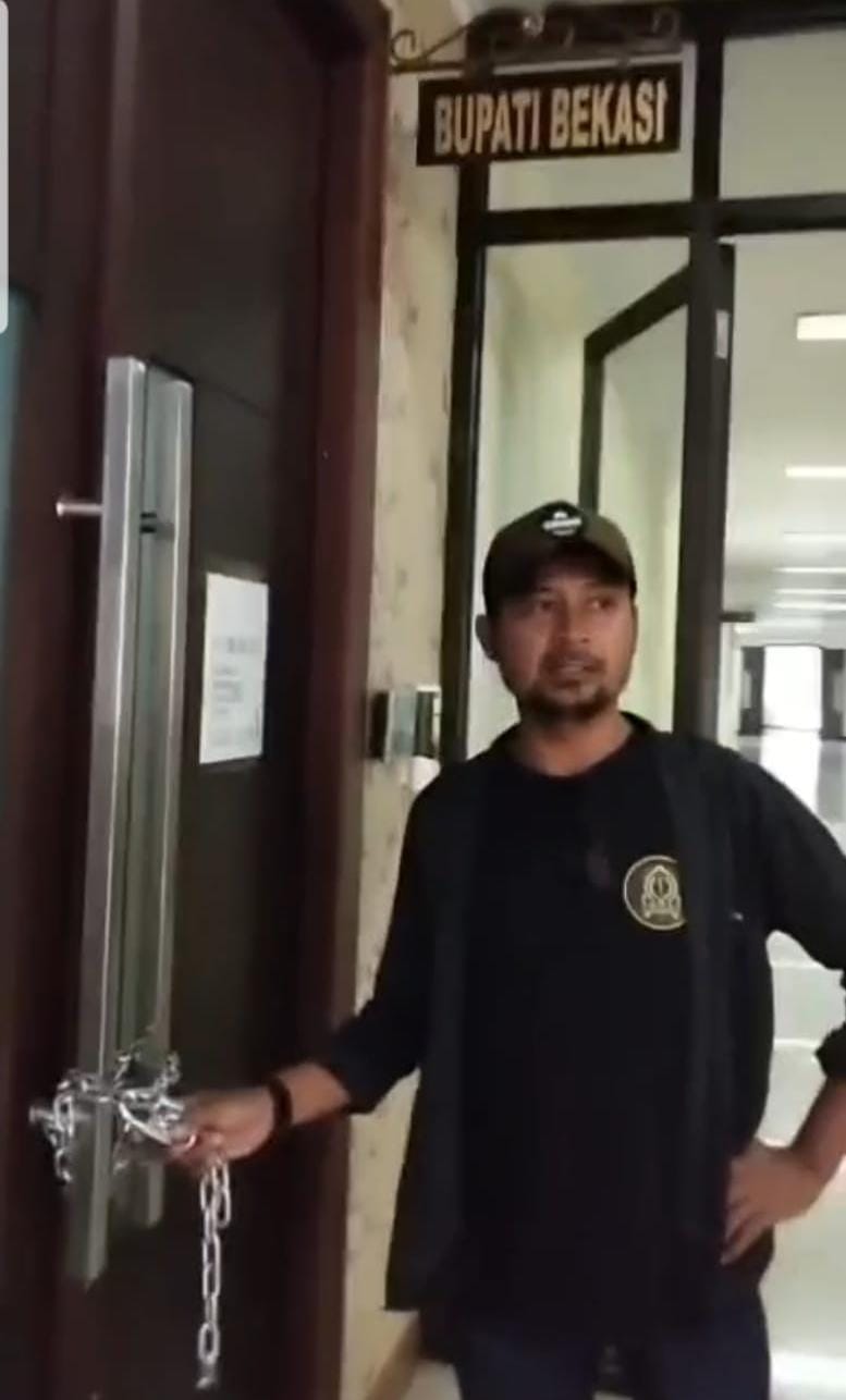 Keterangan foto: Beberapa orang memggembok pintu Kantor Bupati Bekasi, Jumat 18/9/226